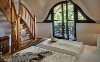 Schlafzimmer mit Balkon und Treppe ins Dachgeschoss